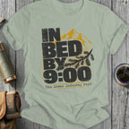 Light green t-shirt with black text "IN BED BY 9:00 The Great Indoorsy Tour" and mountains.