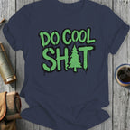 Navy t-shirt with green graffiti-style text "DO COOL SH*T" and a small evergreen tree.