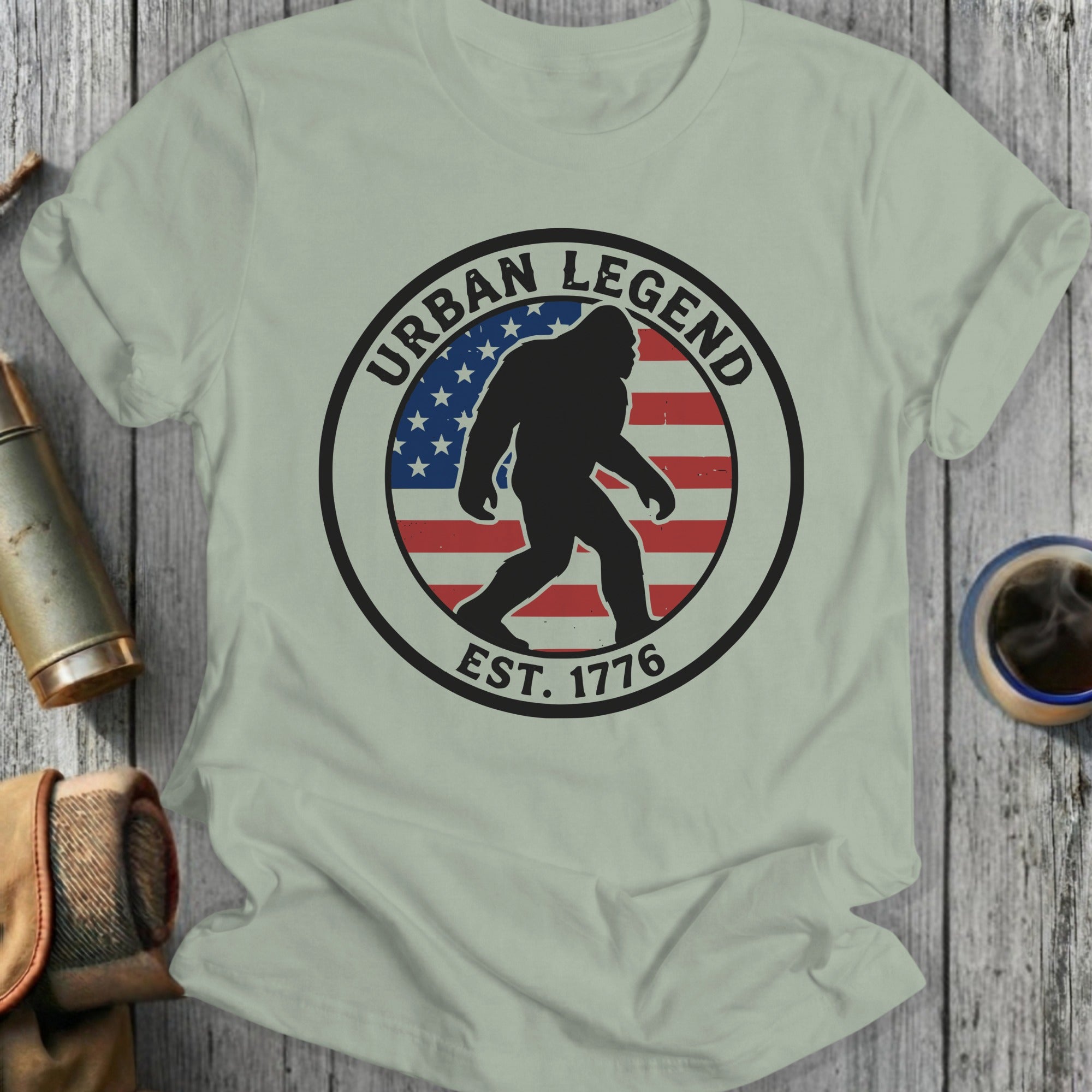Black Bigfoot silhouette inside circle with US flag and "Urban Legend Est. 1776".