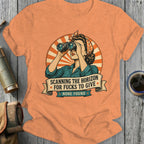 Woman in bandana looks through binoculars on shirt with text "Scanning the horizon for fucks to give".