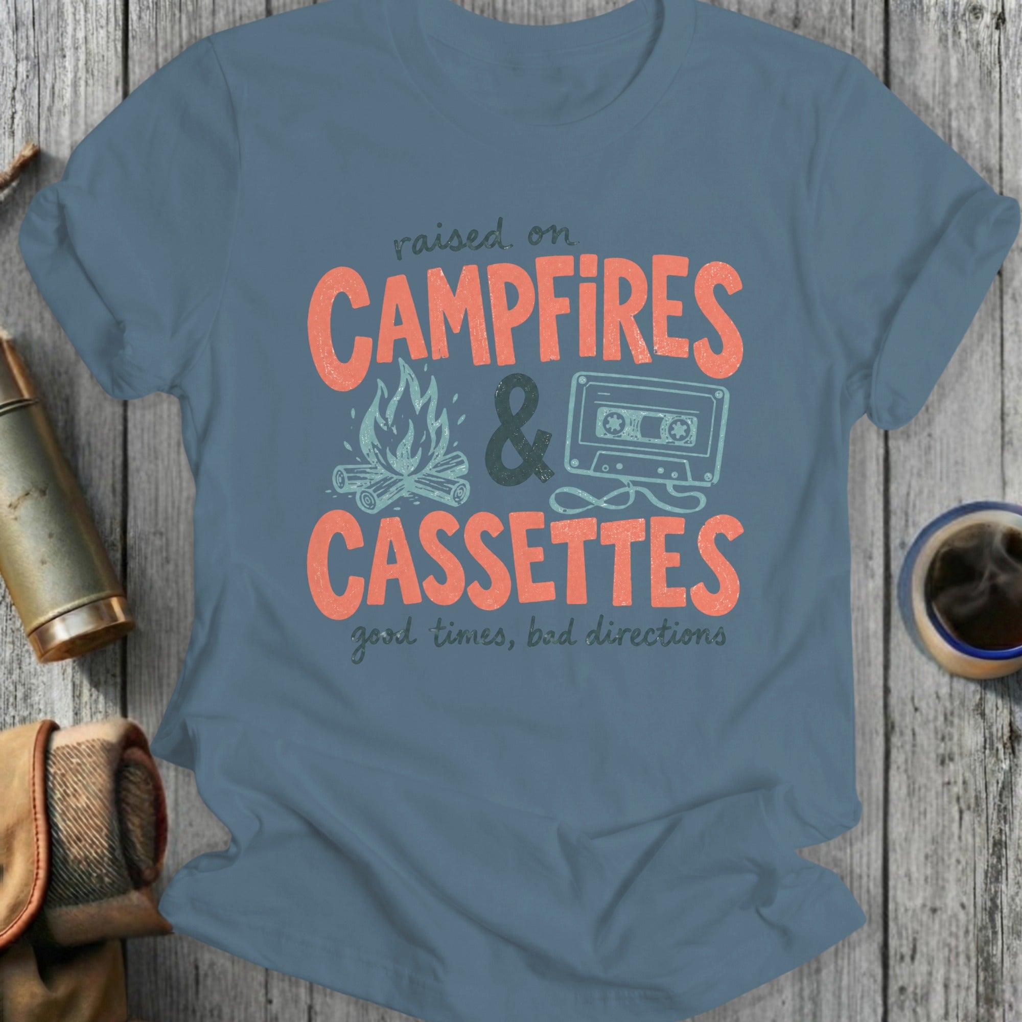 T-shirt with "Raised on Campfires & Cassettes" graphic.