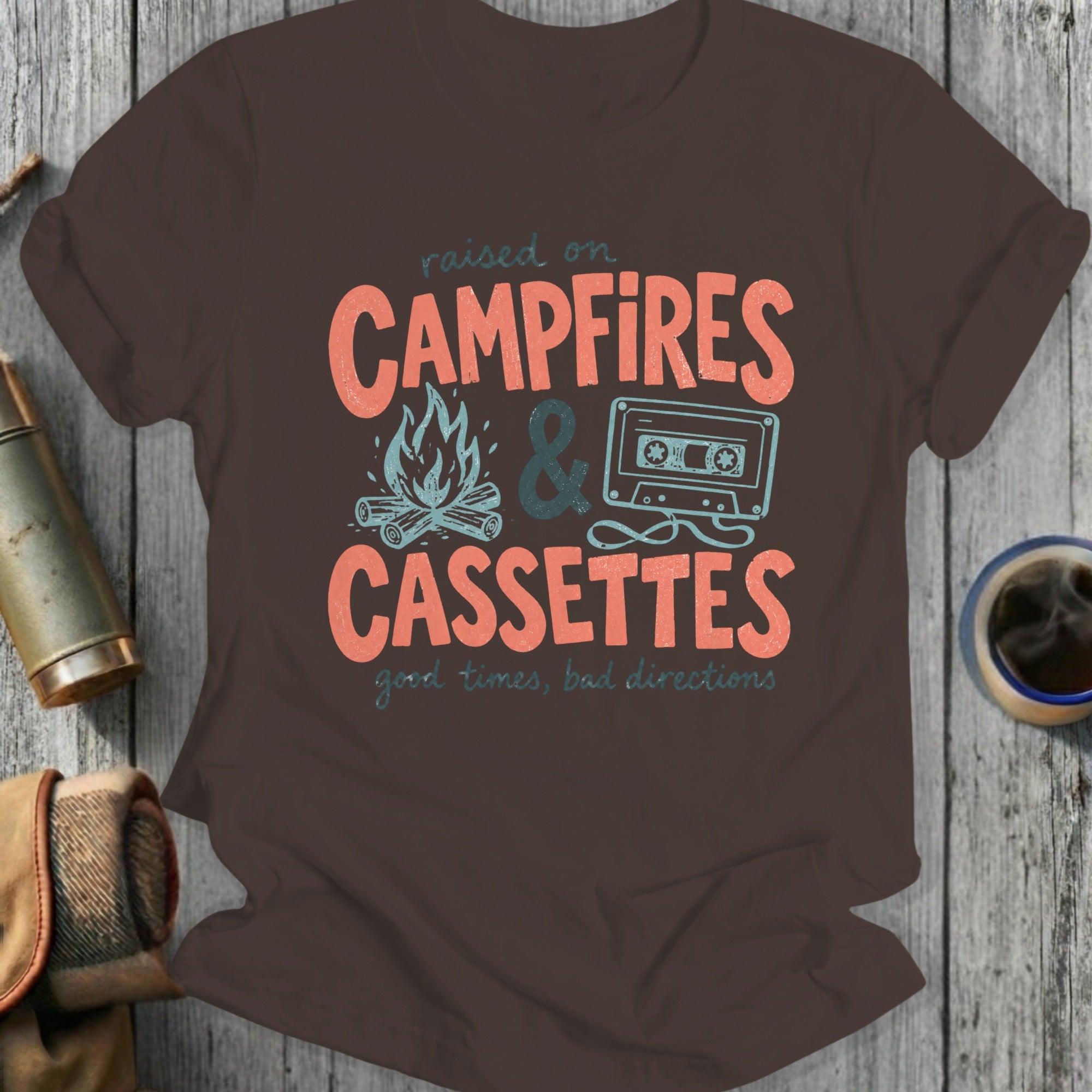 Brown t-shirt with "Raised on Campfires & Cassettes" graphic.