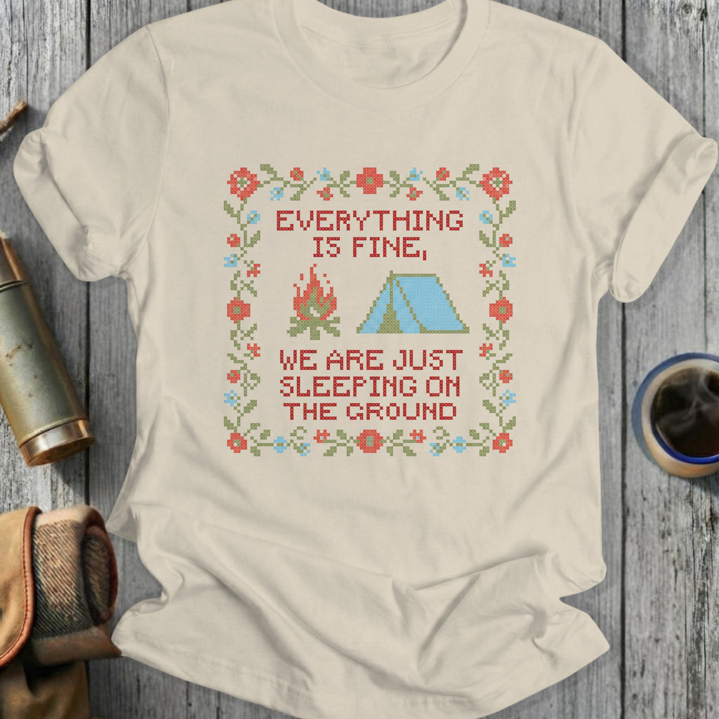 T-shirt with embroidered campsite and text "EVERYTHING IS FINE, WE ARE JUST SLEEPING ON THE GROUND".