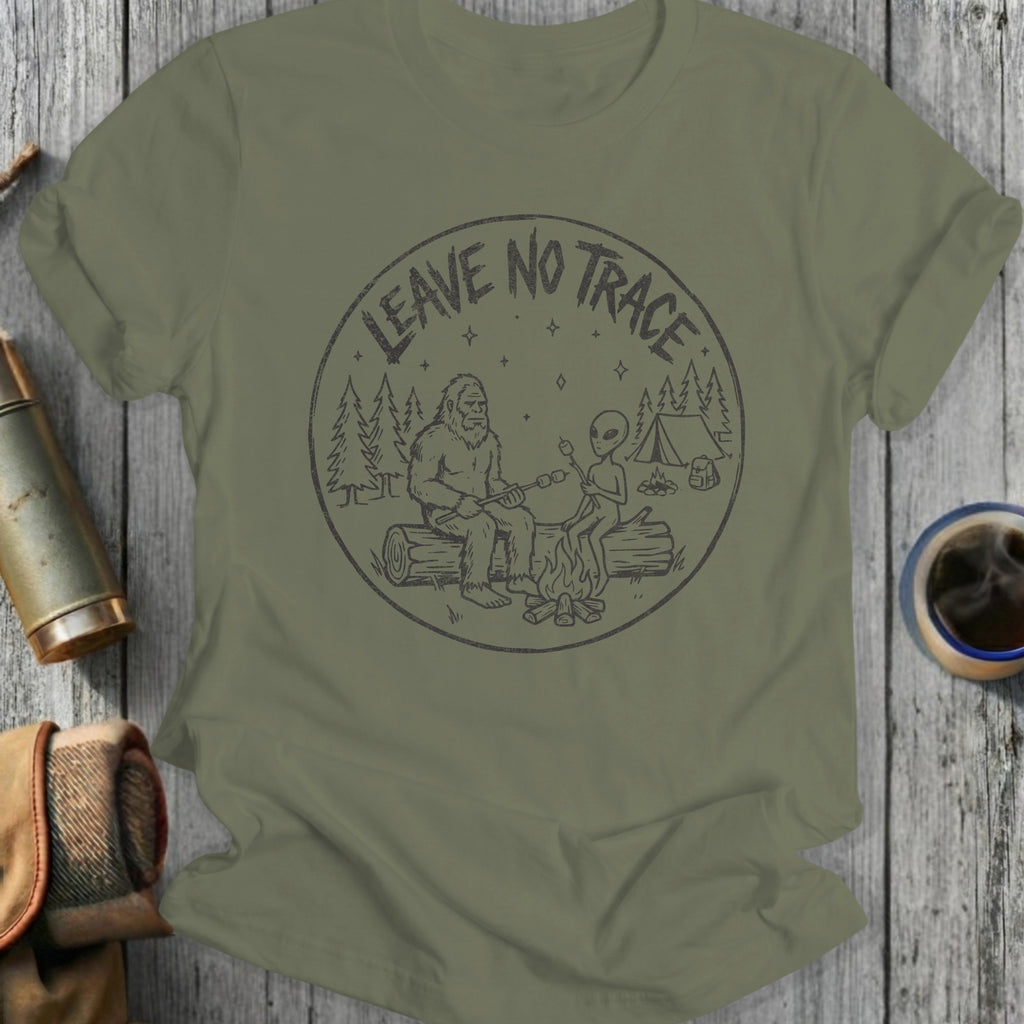 Bigfoot and alien roast marshmallows by campfire, with "Leave No Trace" text.