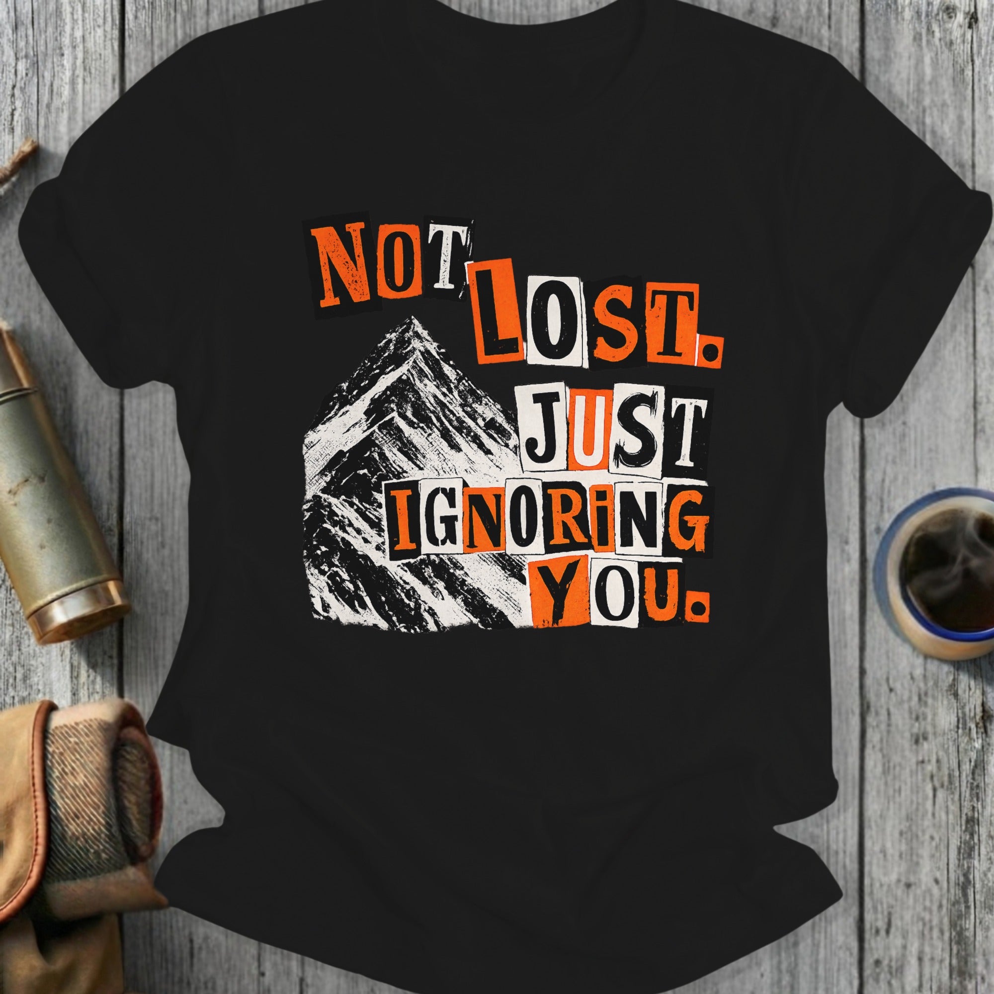 Black t-shirt with "Not Lost. Just Ignoring You." text over mountains.