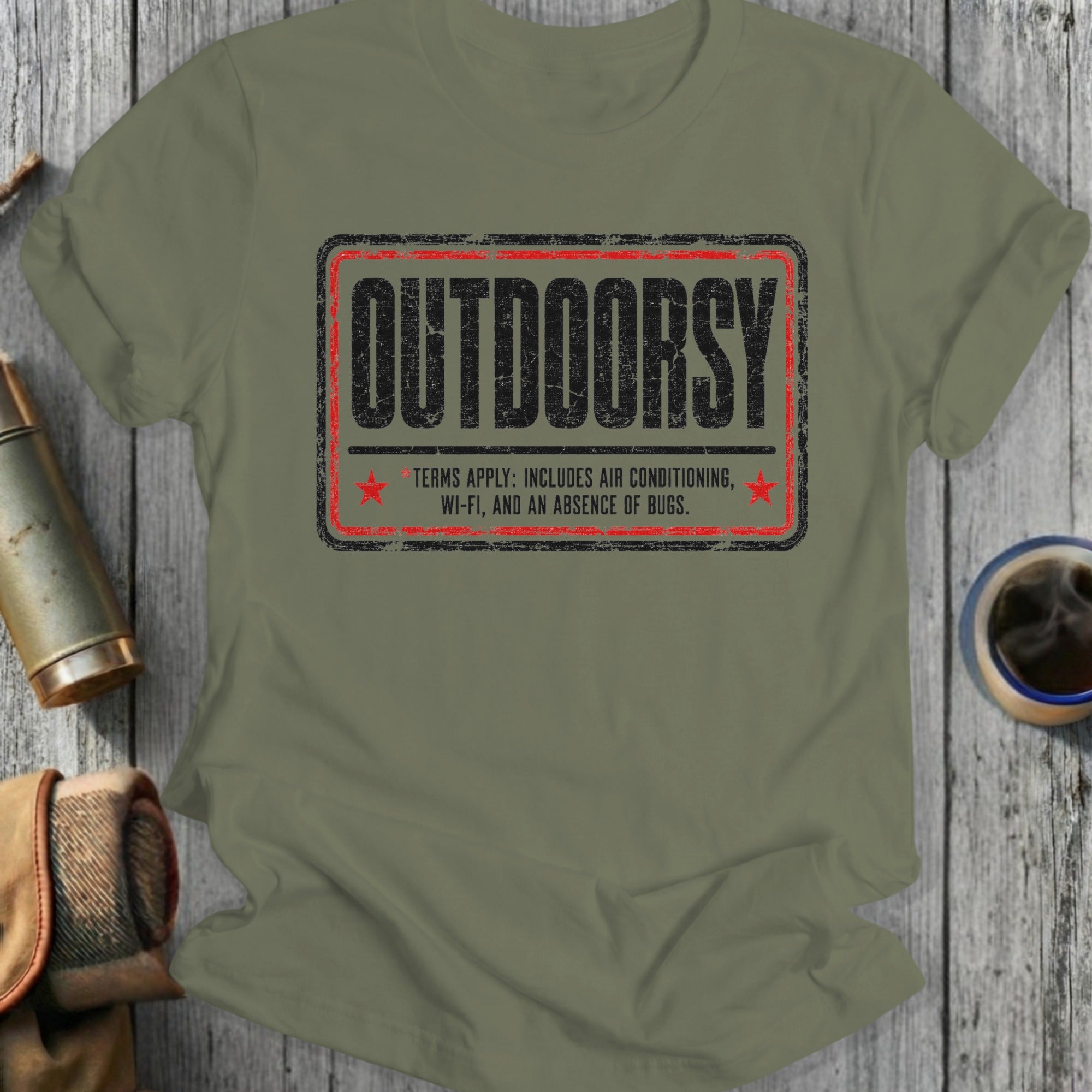 Green t-shirt with distressed text reading "OUTDOORSY" and humorous terms.