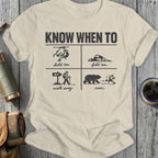 T-shirt with four panels illustrating "Know When To" hold 'em, fold 'em, walk away, and run from a bear.