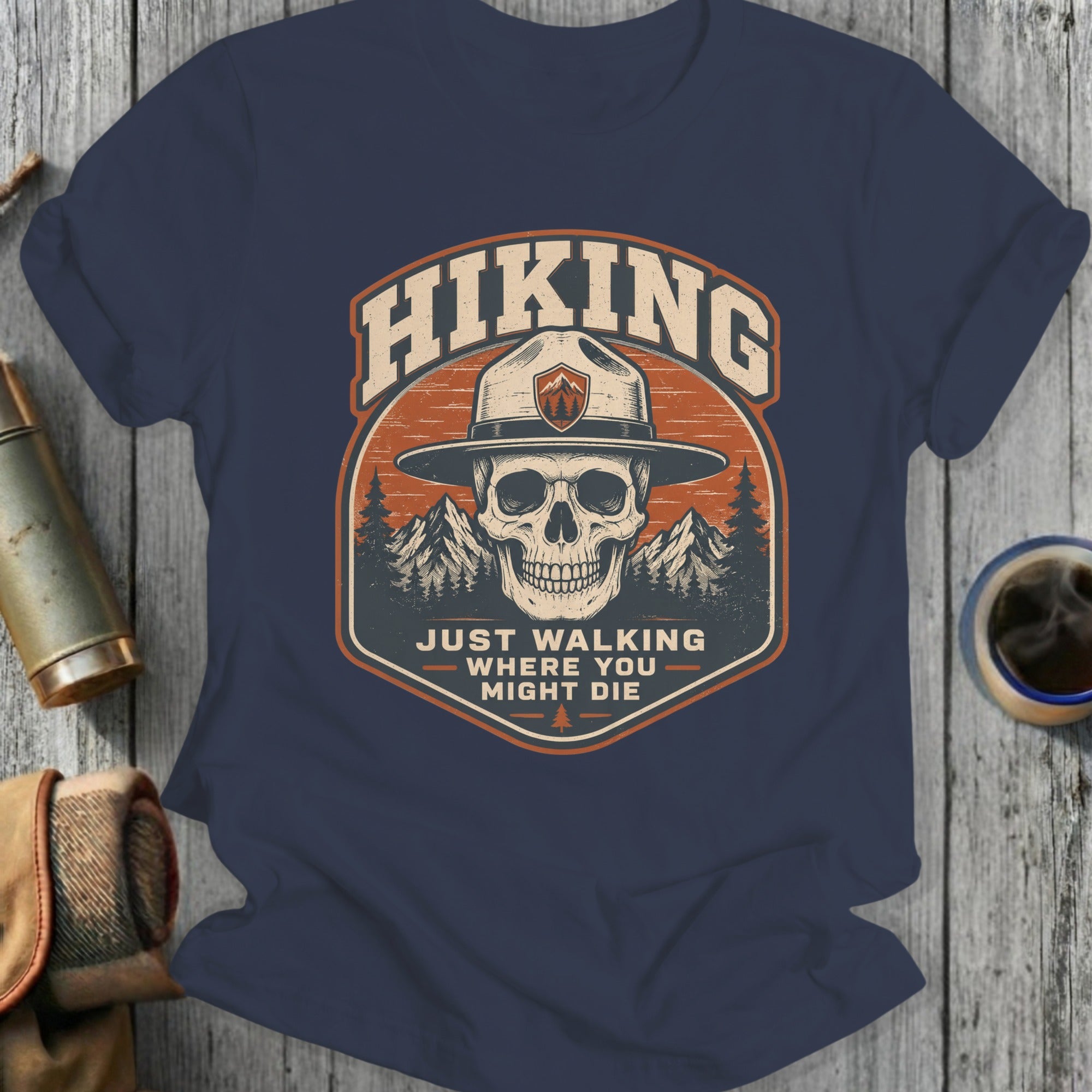 Hiking skull wearing ranger hat, mountains, "Just walking where you might die" text.