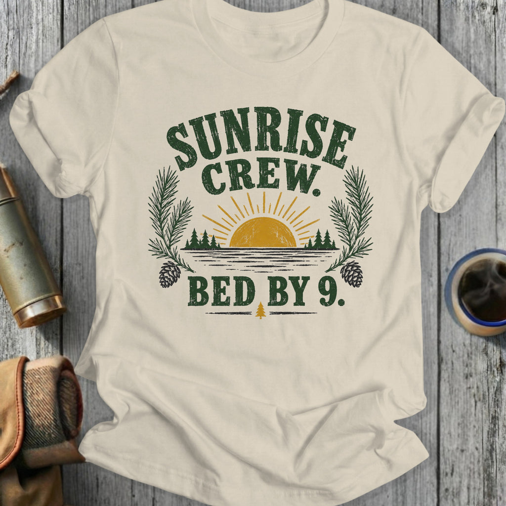 Cream t-shirt with "Sunrise Crew. Bed by 9." text and nature graphic.