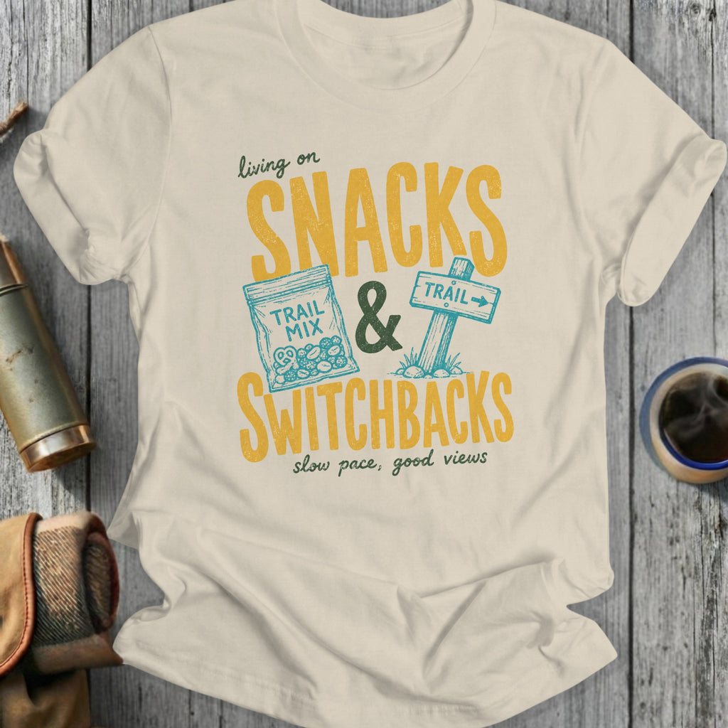 T-shirt with yellow text: "living on SNACKS & SWITCHBACKS slow pace, good views"