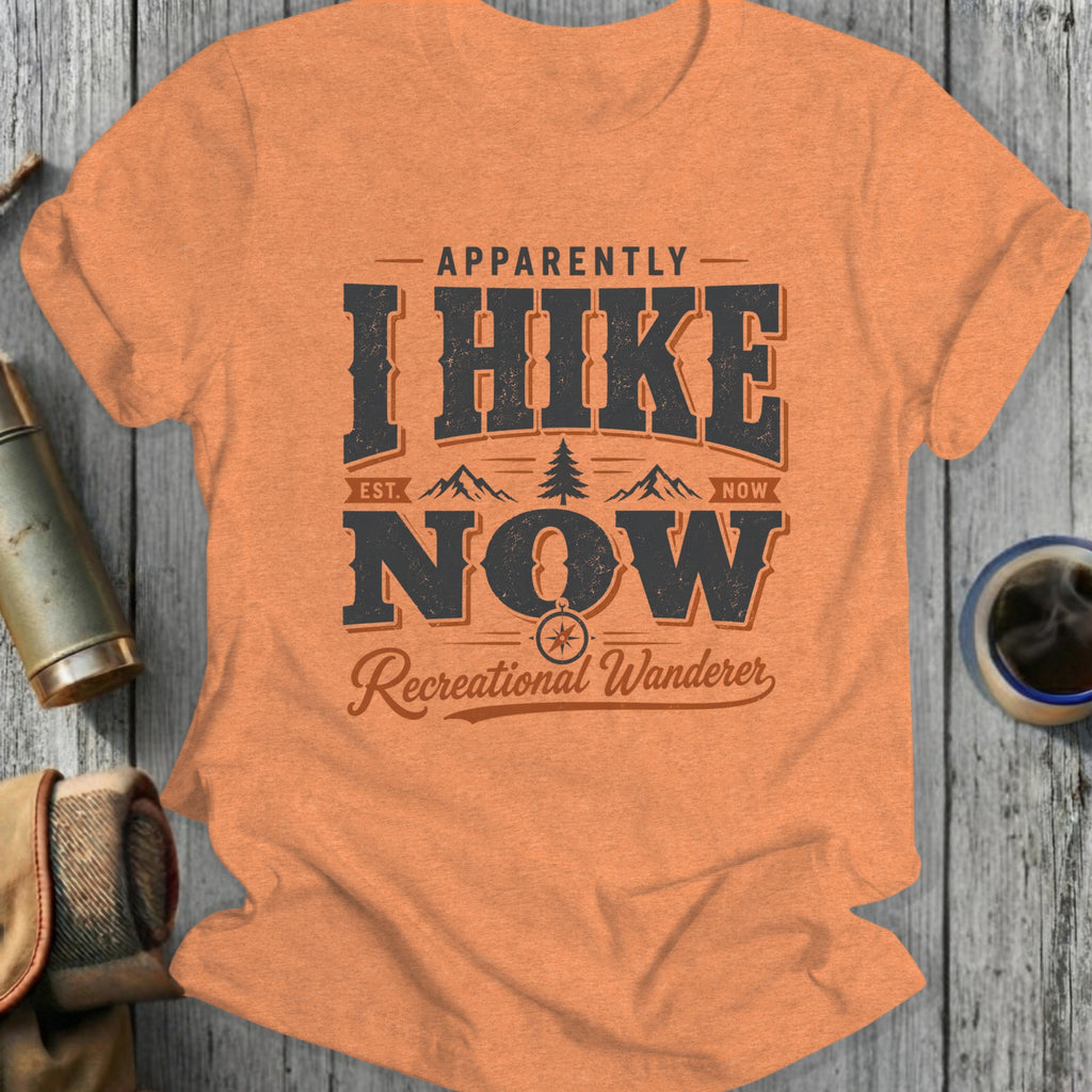 Orange t-shirt with "Apparently I Hike Now Recreational Wanderer" graphic.