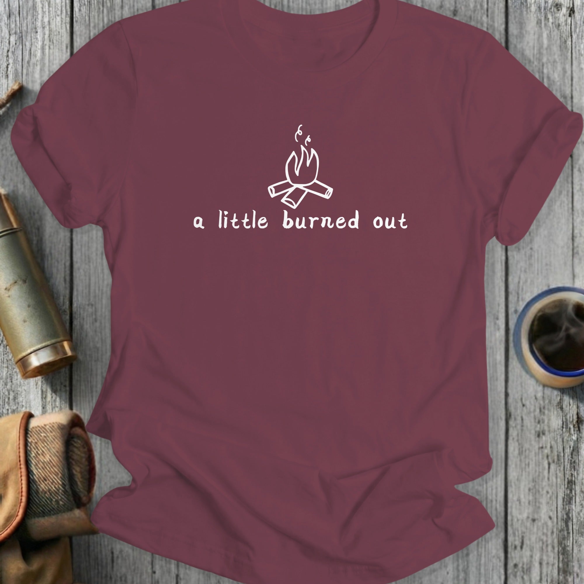 Maroon t-shirt with white campfire graphic and text: a little burned out