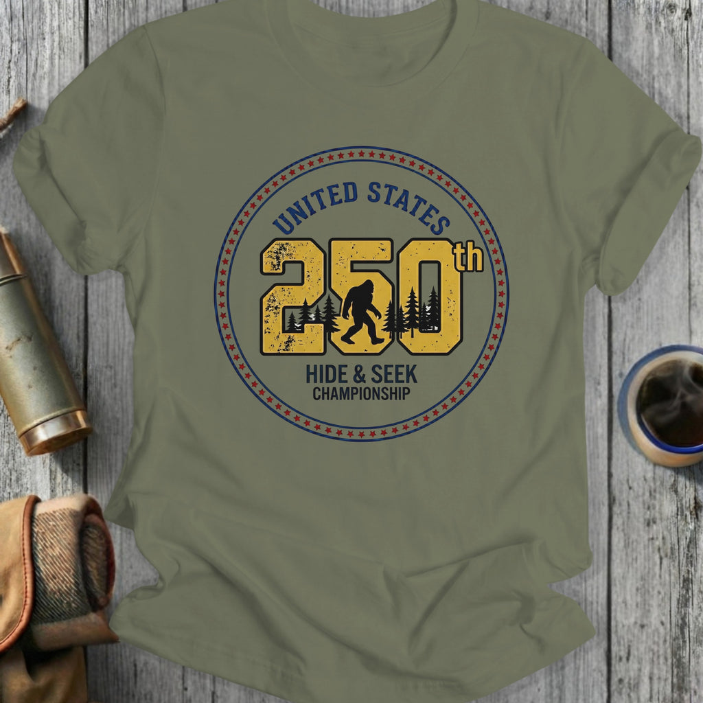Olive t-shirt with "United States 250th Hide & Seek Championship" Bigfoot graphic.