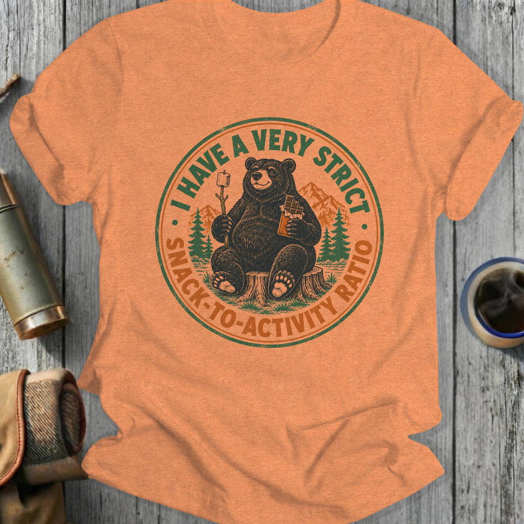 Orange t-shirt with a round graphic of a bear holding a marshmallow and chocolate bar.