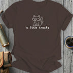 Brown t-shirt with white outline of a raccoon and text "a little trashy".