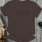Brown t-shirt with line drawing of mountains, campfire, tree, and tent, and text "BE KIND TO ALL CLIMBS".
