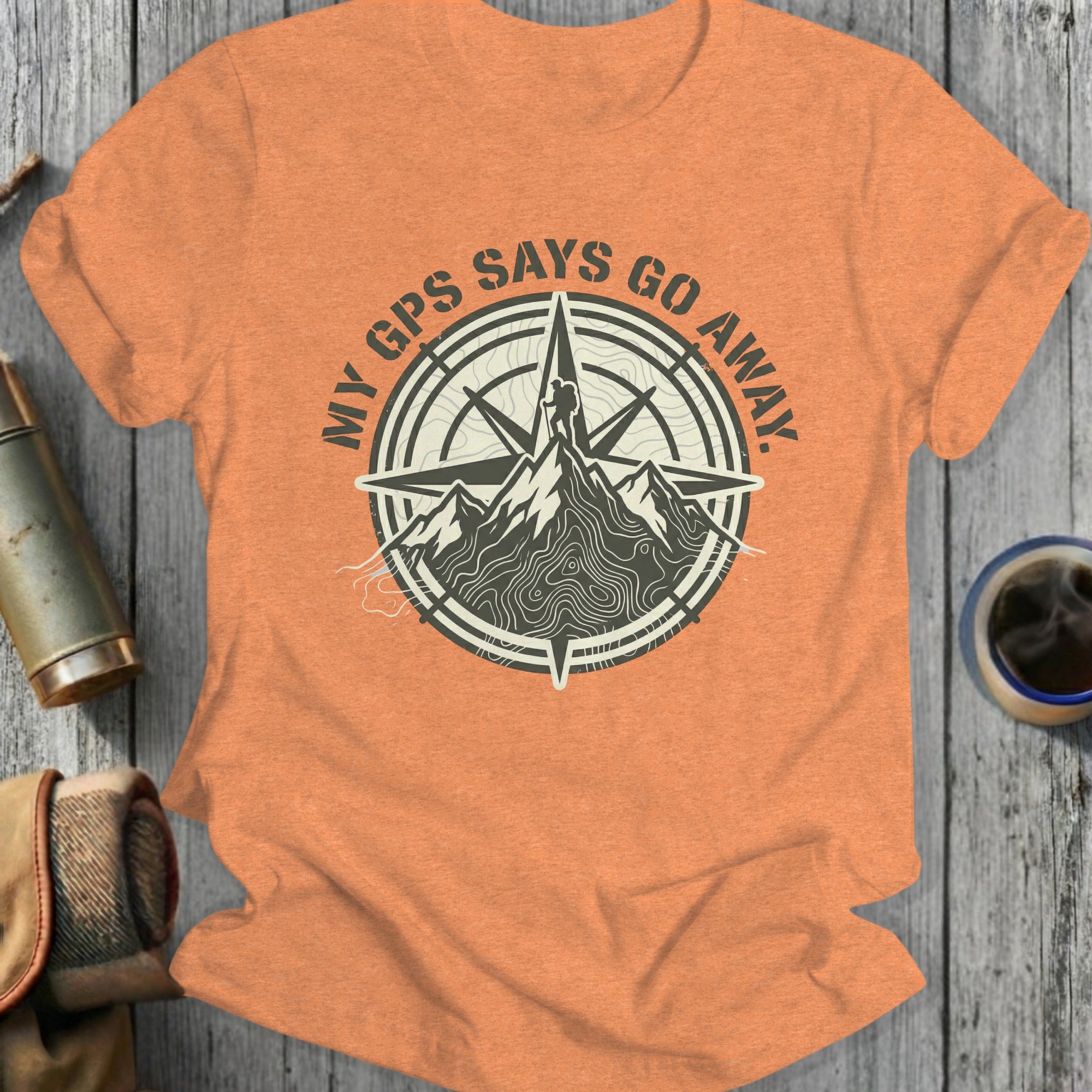Orange t-shirt with compass graphic and mountain with text "My GPS Says Go Away."