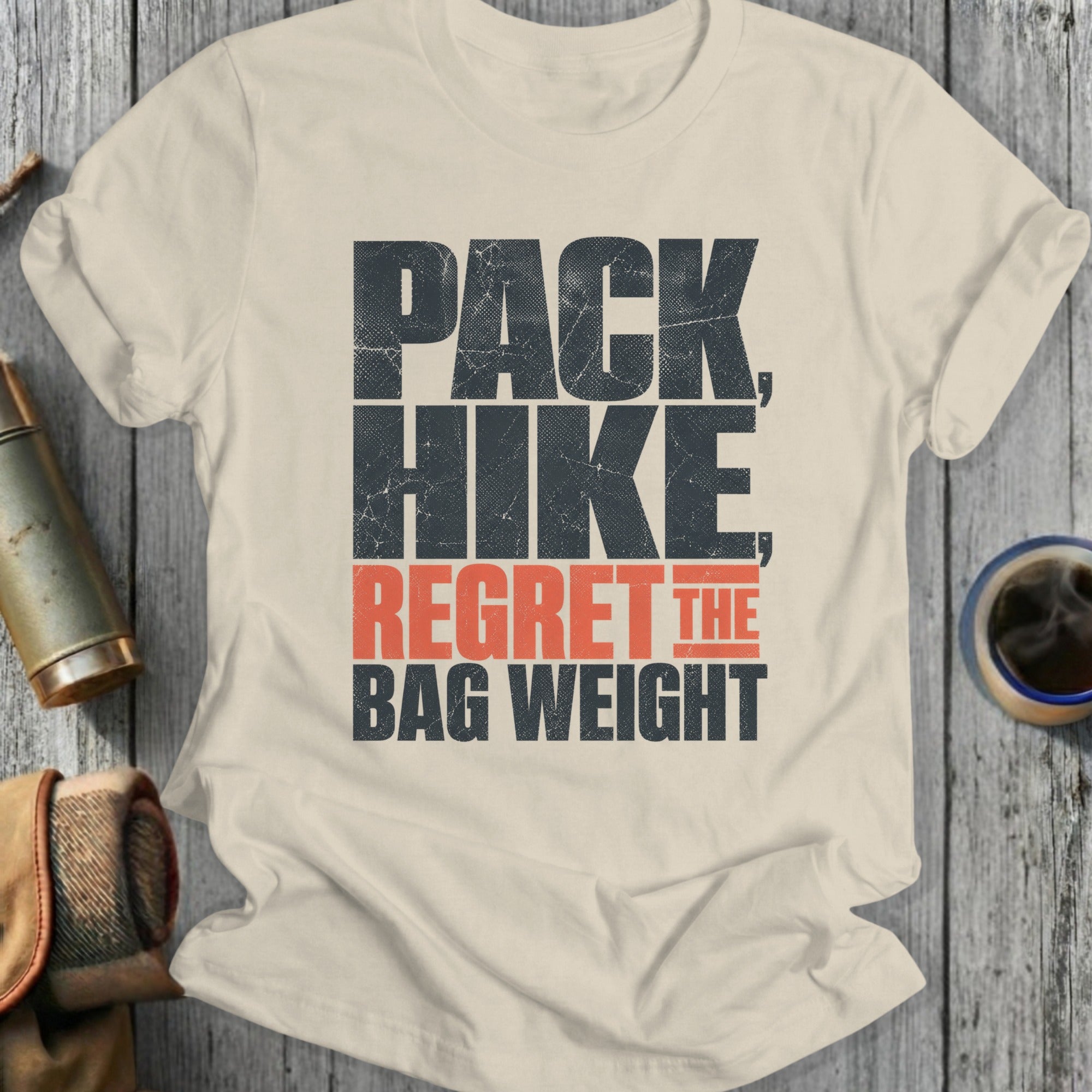 Cream t-shirt with "PACK HIKE REGRET THE BAG WEIGHT" text.