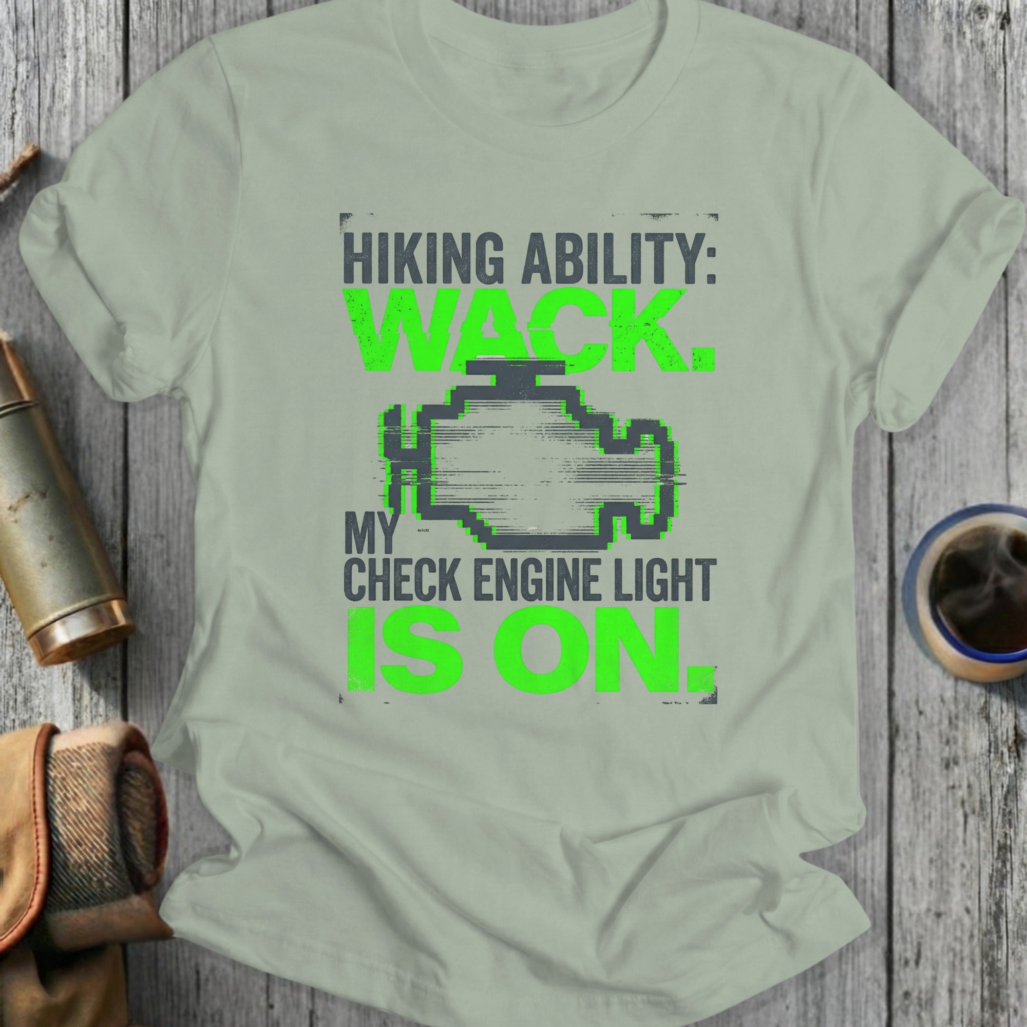 T-shirt with green text and check engine light graphic about hiking.