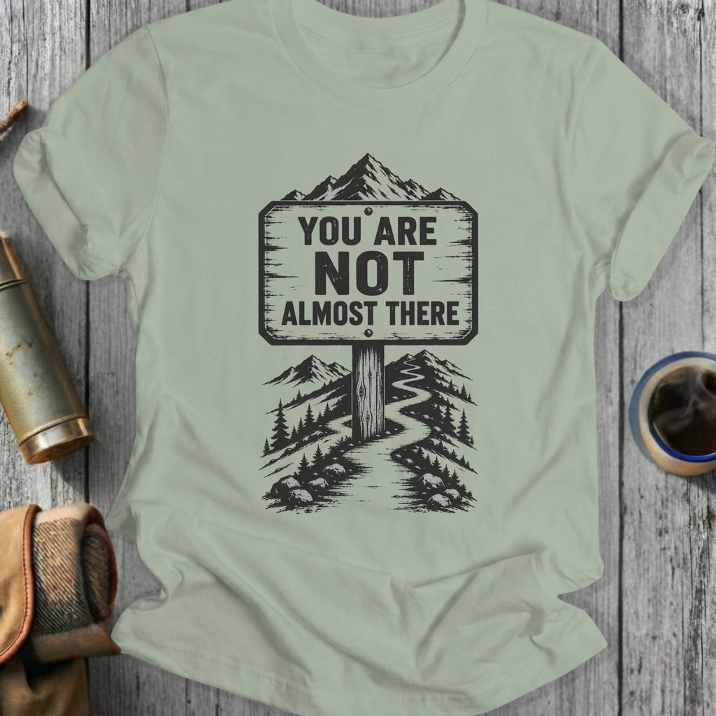 Shirt with a sign saying "You Are Not Almost There" on a mountain trail.