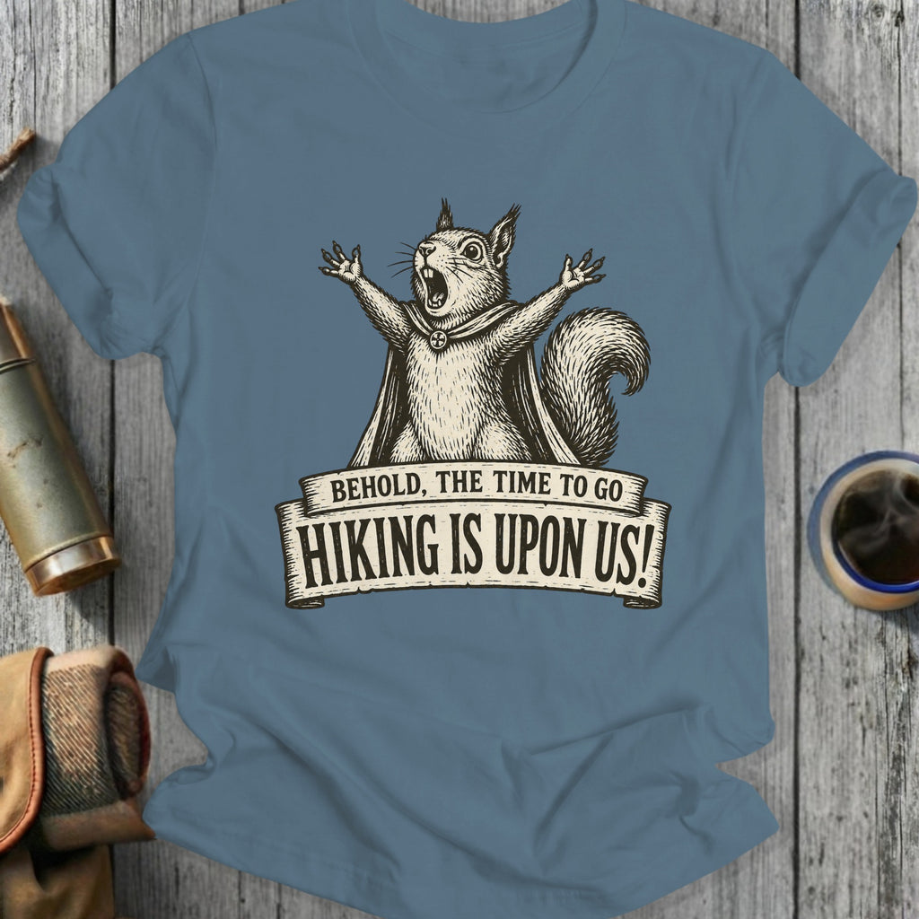 T-shirt graphic of a yelling squirrel wearing a cape and the text "Behold, the time to go Hiking is upon us!"