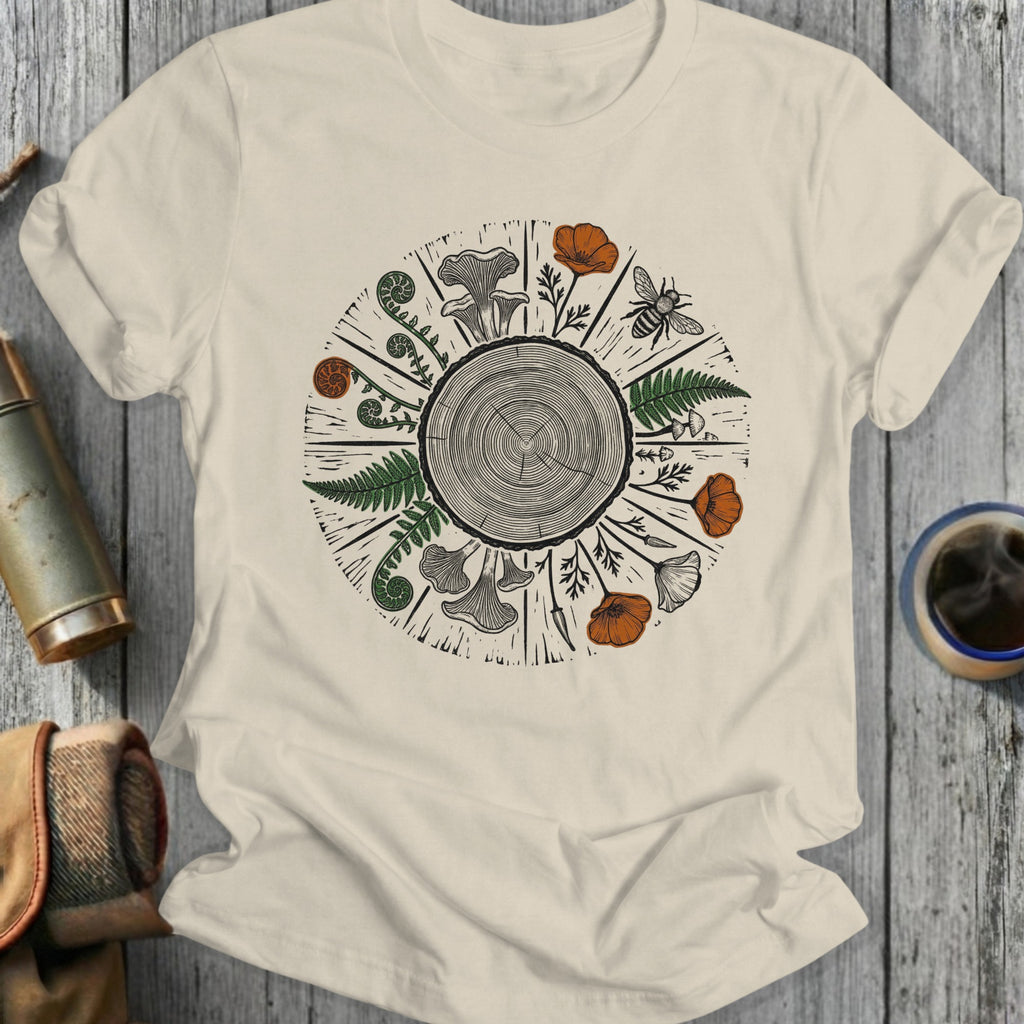 T-shirt with wood grain circle, ferns, mushrooms, poppies, and a bee.
