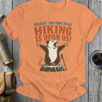 Opossum on a tree stump with arms outstretched, holding a hiking pole.