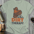 Light green t-shirt with orange hiking boot graphic and text "DIRT THERAPY".