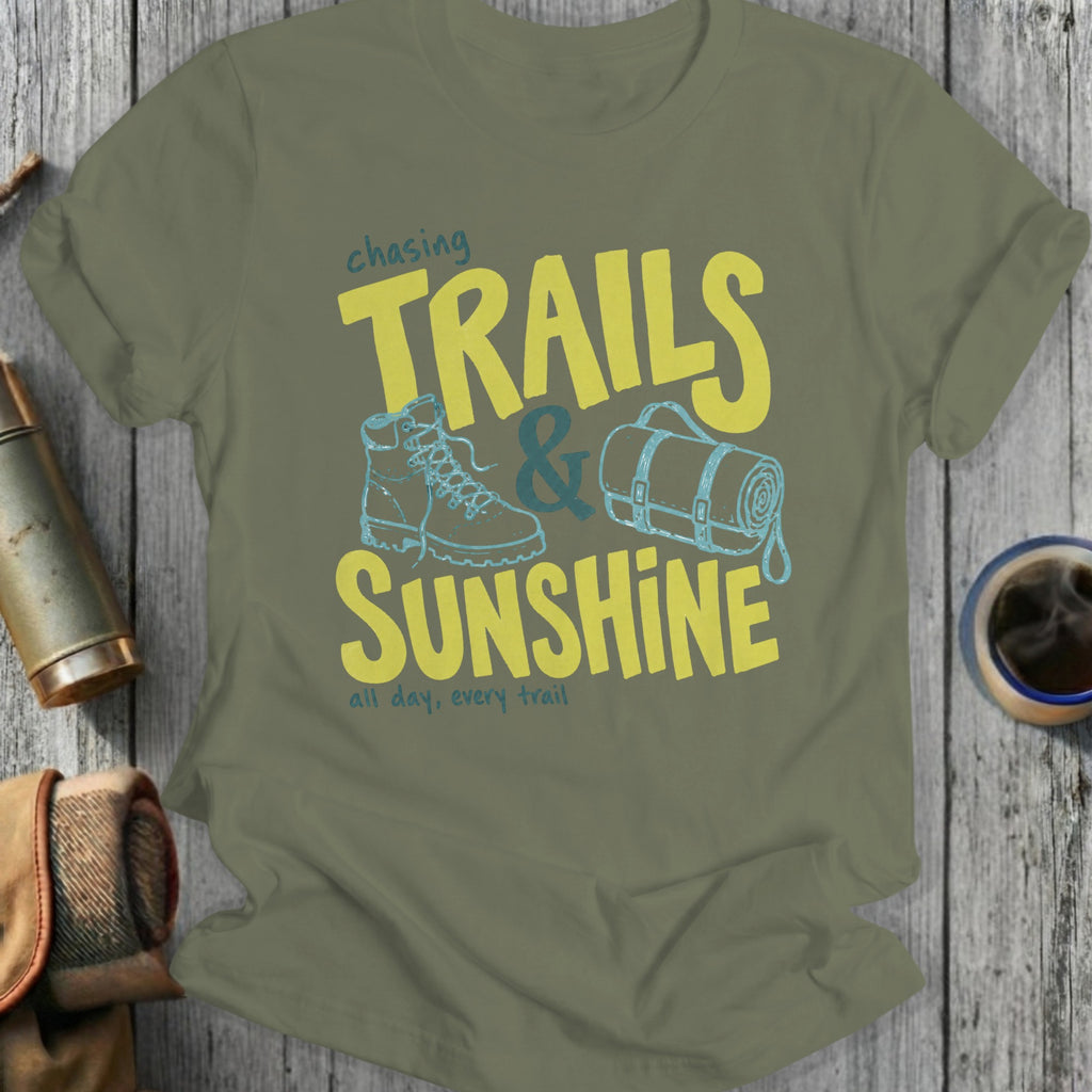 Olive t-shirt with "Chasing Trails & Sunshine" graphic and hiking boot.