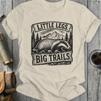 Cream t-shirt with badger, mountains, and "Little Legs Big Trails" text.