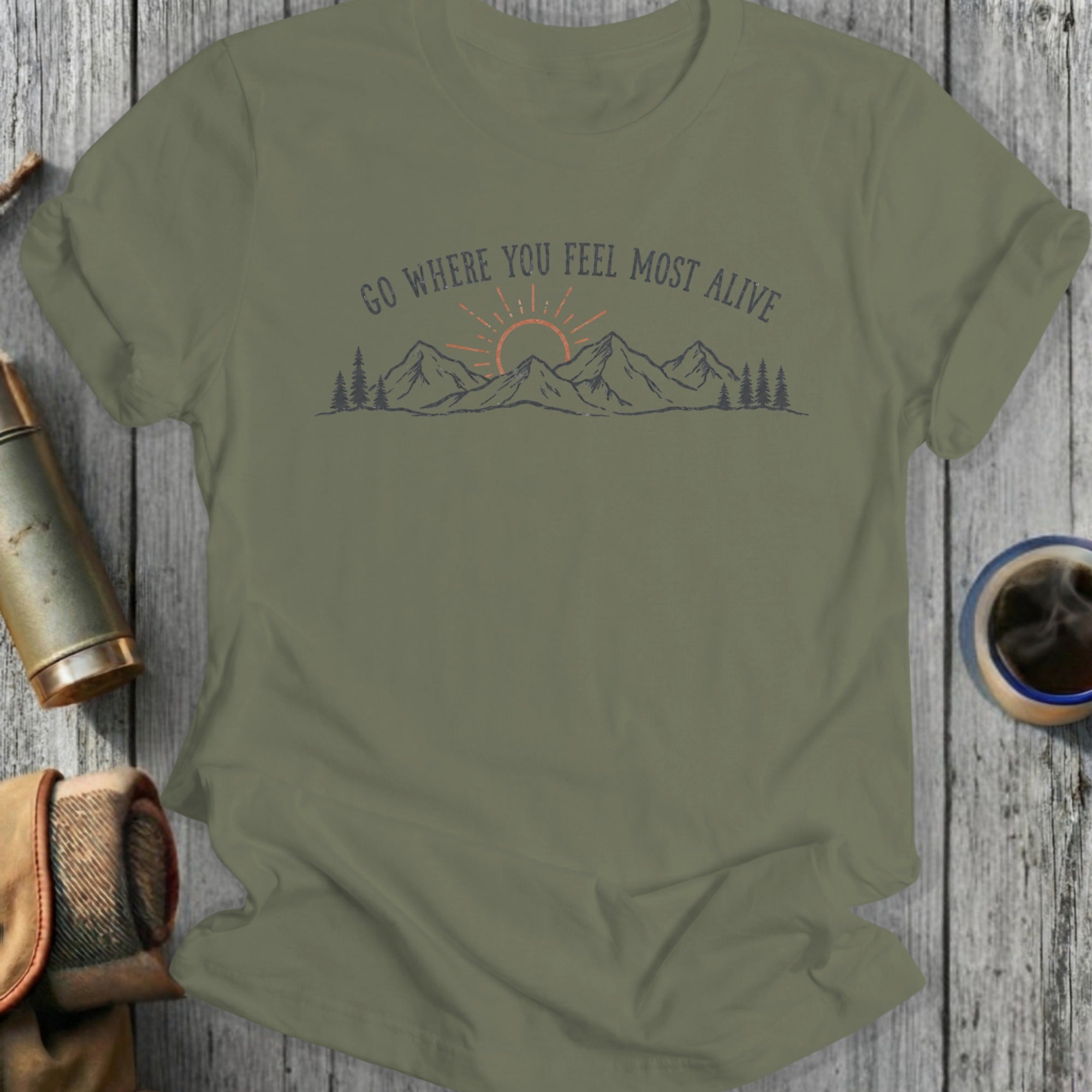 Olive green t-shirt with mountains, sun, and "Go Where You Feel Most Alive" text.