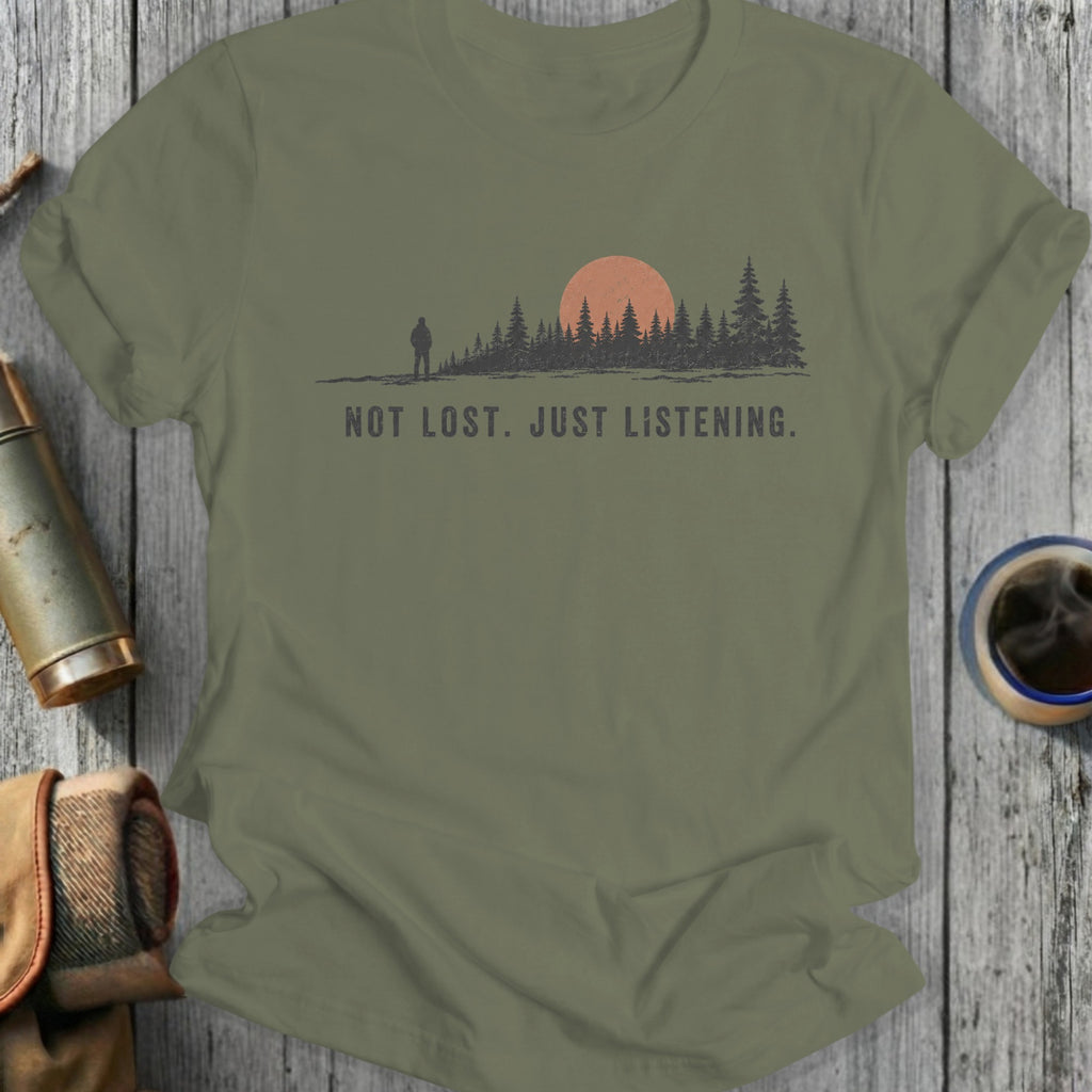 Olive green t-shirt with a forest silhouette, sun, and hiker graphic with text.