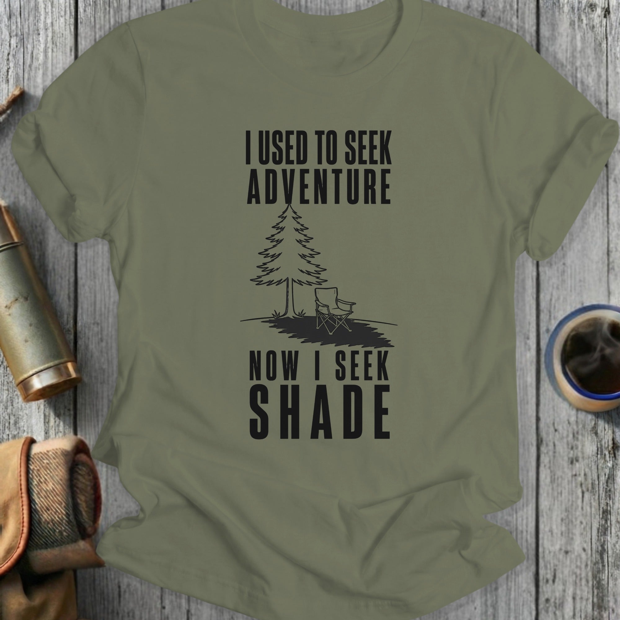 Olive green t-shirt with black text reading "I USED TO SEEK ADVENTURE NOW I SEEK SHADE"