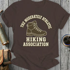 Brown t-shirt with "The Moderately Athletic Hiking Association" text and hiking boot graphic.