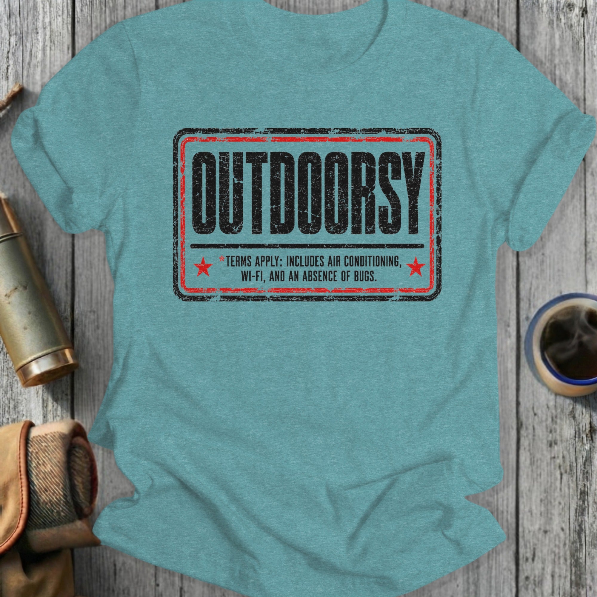 Teal t-shirt with "OUTDOORSY" and "Terms apply: includes air conditioning, Wi-Fi, and an absence of bugs."