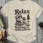 T-shirt with graphic of a raccoon in sunglasses relaxing with a drink, text "Relax Nothing is under control".