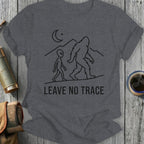 Graphic t-shirt with Bigfoot and alien silhouettes, moon, mountains, and "LEAVE NO TRACE" text.