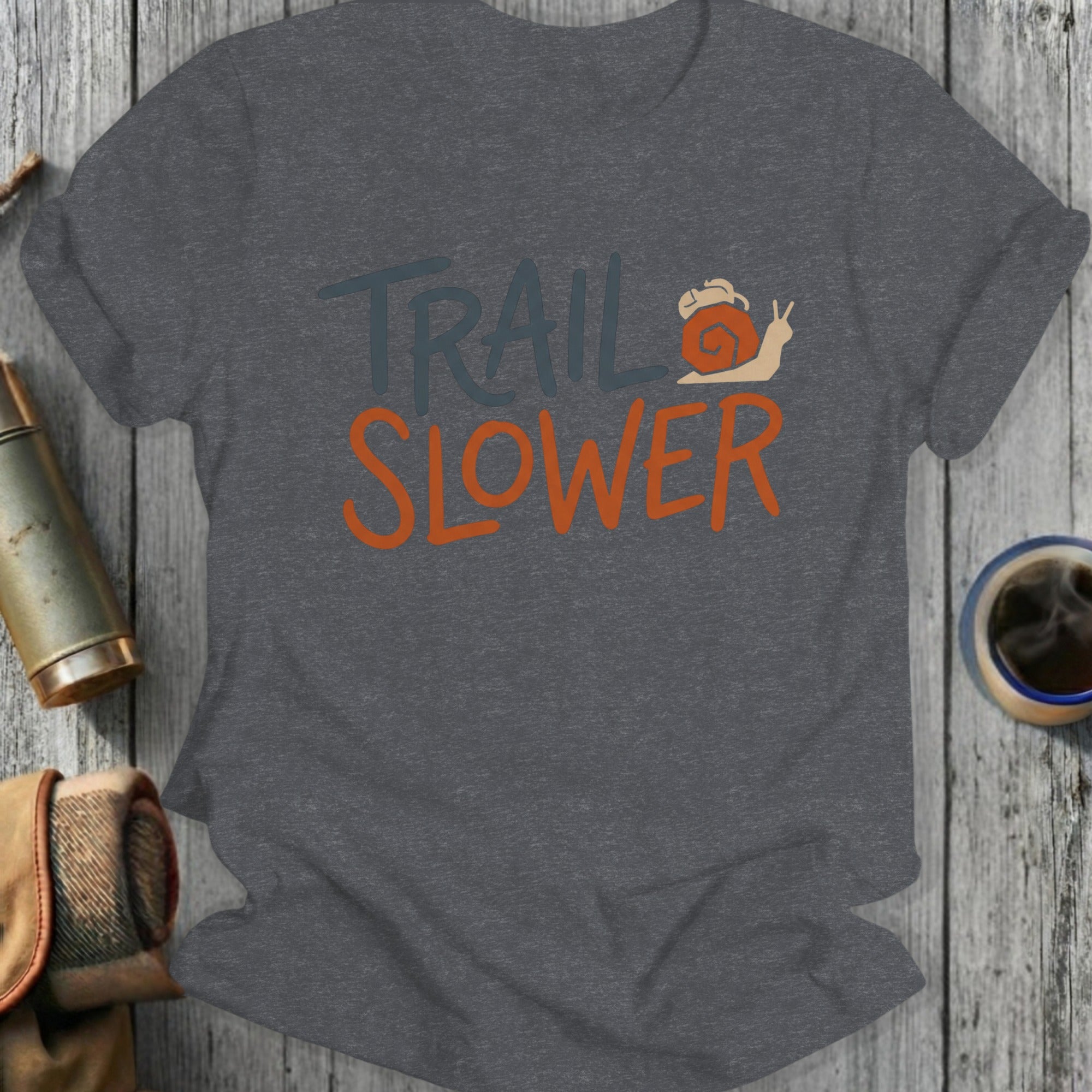 Trail Slower text with a snail on a dark gray t-shirt.