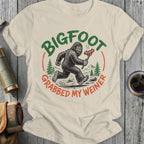 Bigfoot running with a hot dog, text reads "Bigfoot grabbed my weiner."