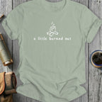 Light green t-shirt with a white graphic of a campfire and text "a little burned out".