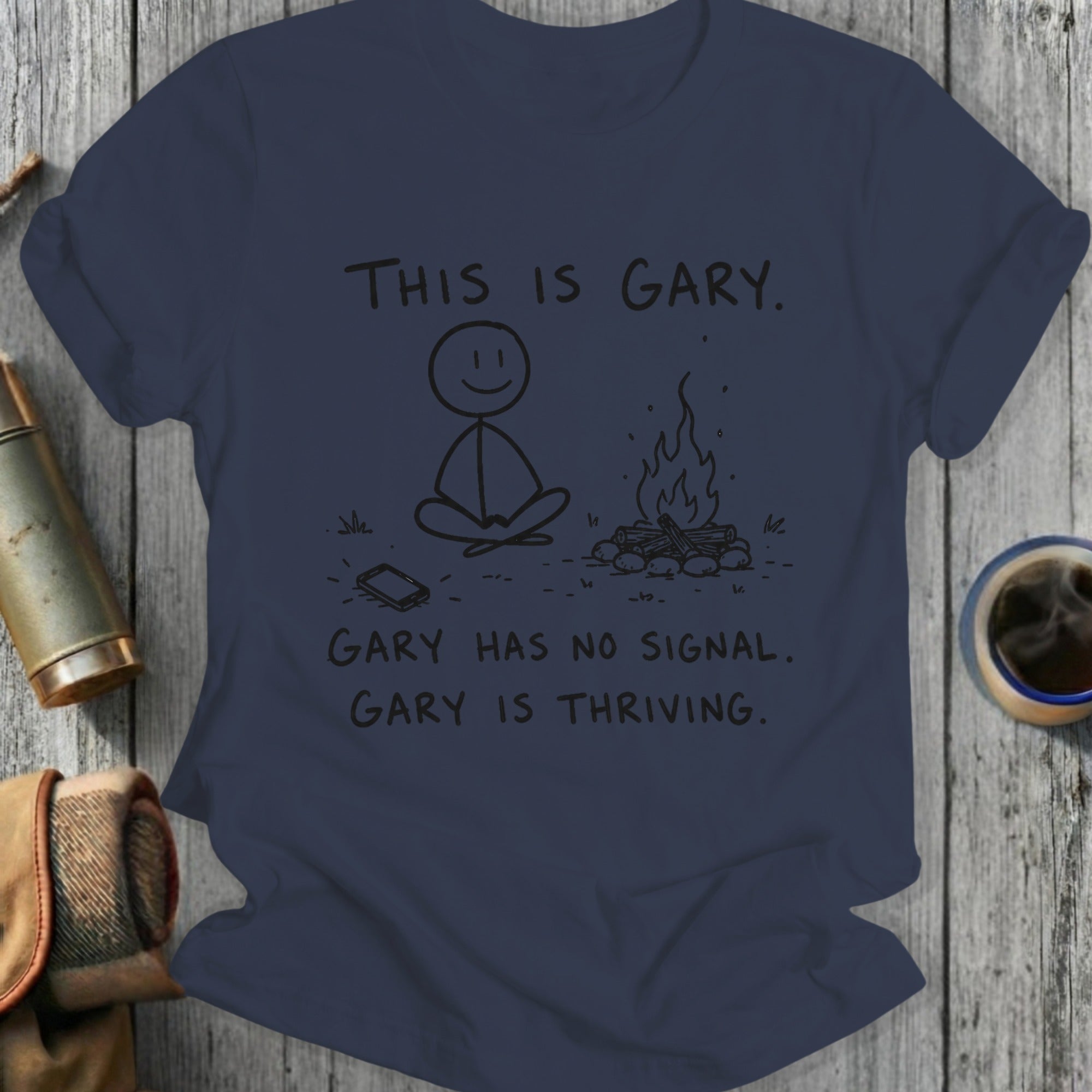 T-shirt with stick figure meditating by campfire, text says "This is Gary. Gary has no signal. Gary is thriving."