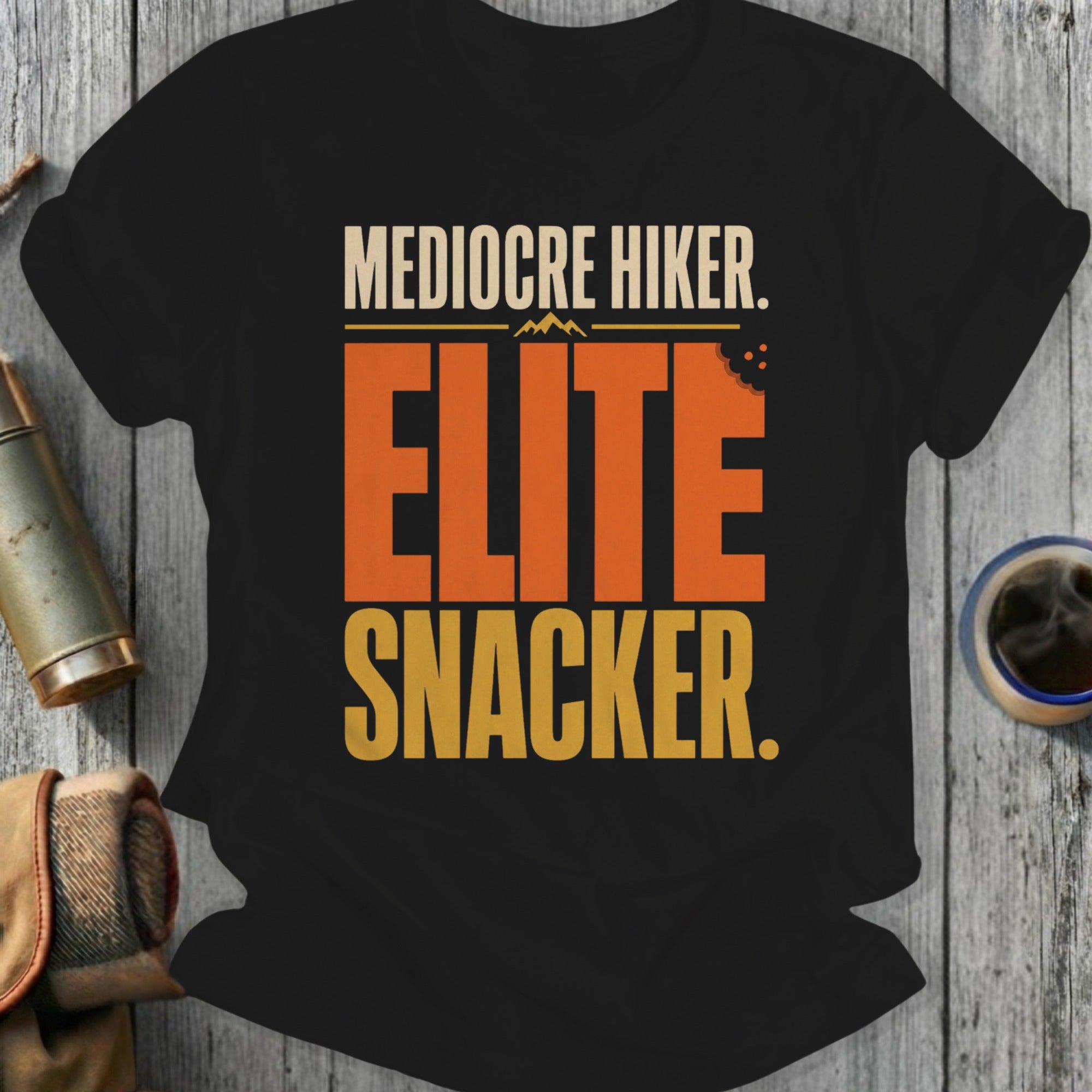 Black t-shirt with text "Mediocre Hiker. Elite Snacker."