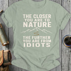 Green t-shirt with text and mountain graphic: "The closer you are to nature, the further you are from idiots."