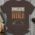 Brown t-shirt with "Dinosaurs Didn't Hike" text, footprints, and dinosaur graphic.